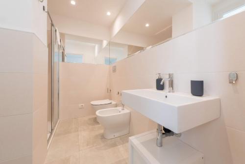 モーディカにあるVilla White - IsulaTravelの洗面台とトイレを備えた白いバスルーム
