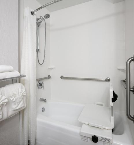 a white bathroom with a shower and a tub at Holiday Inn Hotel & Suites Overland Park-West by IHG in Overland Park