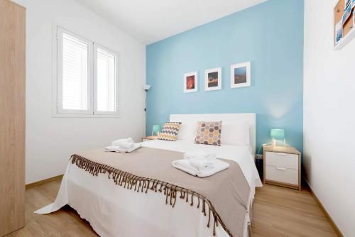 Un dormitorio con una cama grande con una pared azul. en Sea Home - IsulaTravel, en Marina di Modica