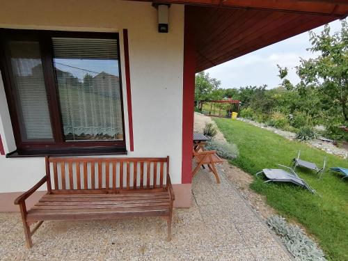a wooden bench sitting outside of a house at Penzion Nad jezerem in Pavlov