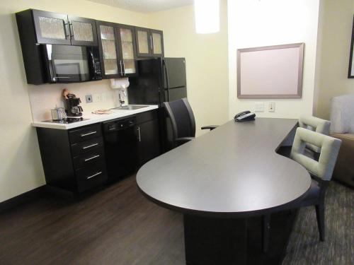 a small kitchen with a table and a refrigerator at Candlewood Suites Lake Mary by IHG in Lake Mary