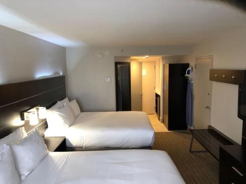a hotel room with two beds and a bathroom at Holiday Inn Express Hotel & Suites Miami - Hialeah by IHG in Hialeah