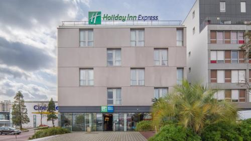 a large white building with a sign on it at Holiday Inn Express Saint-Nazaire by IHG in Saint-Nazaire