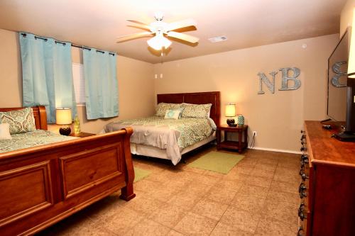 a bedroom with two beds and a ceiling fan at Shady River Oasis in New Braunfels