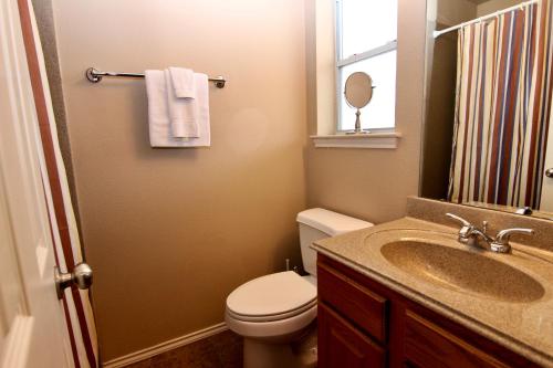 a bathroom with a sink and a toilet and a mirror at Shady River Oasis in New Braunfels