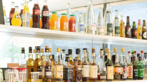 a shelf full of different types of bottles of alcohol at Holiday Inn Express Saint-Nazaire by IHG in Saint-Nazaire