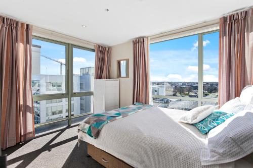 um quarto com uma cama e uma grande janela em Apartment in the heart of the city em Christchurch