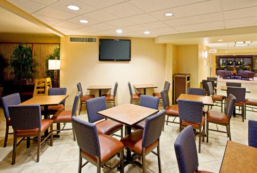 a restaurant with tables and chairs and a flat screen tv at Holiday Inn Express Scottsdale North by IHG in Scottsdale