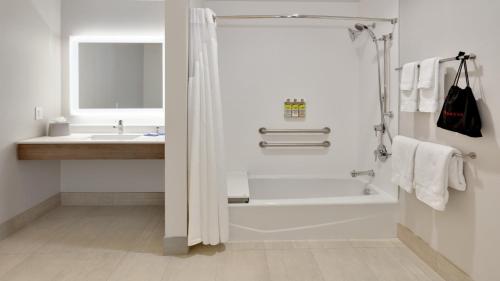 baño blanco con ducha y lavamanos en Holiday Inn Express Hotel & Suites Oklahoma City-West Yukon, an IHG Hotel, en Yukon