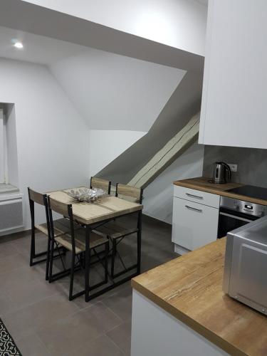 a kitchen with a table and chairs in a room at Les Appartements de la Gare in Colmar