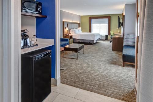 a hotel room with a bedroom and a bed at Holiday Inn Express Hotel & Suites Memphis Southwind, an IHG Hotel in Memphis