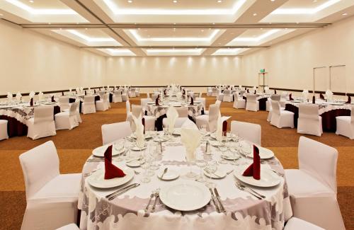a large banquet hall with white tables and white chairs at Holiday Inn Mexico City-Plaza Universidad by IHG in Mexico City