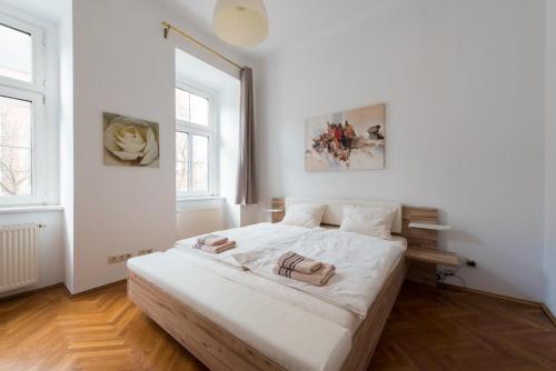 a white bedroom with a large white bed in it at Belvedere Central Apartment in Vienna