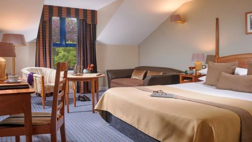 a hotel room with a bed and a living room at The Parkavon Hotel in Killarney