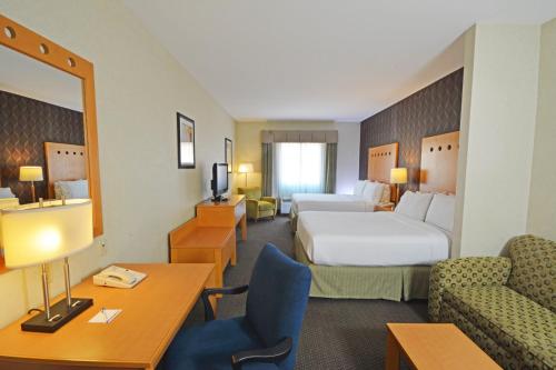 a hotel room with two beds and a table and chairs at Holiday Inn Express & Suites Monterrey Aeropuerto by IHG in Monterrey