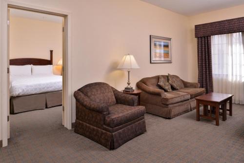 a hotel room with a bed and a chair and a bedroom at Staybridge Suites Oklahoma City, an IHG Hotel in Oklahoma City