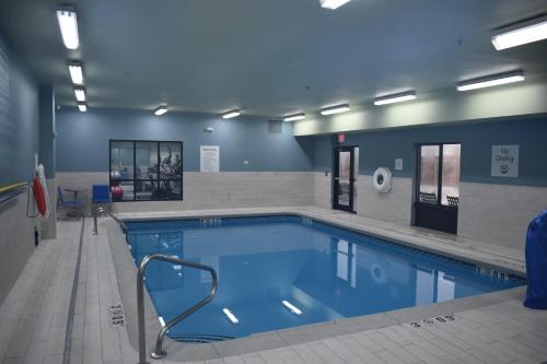 ein großer Pool in einem Gebäude mit blauen Wänden in der Unterkunft Holiday Inn Express Hotel & Suites McPherson, an IHG Hotel in McPherson