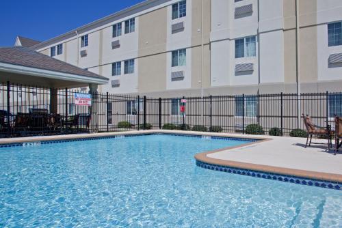 una piscina frente a un edificio en Candlewood Suites Port Arthur/Nederland, an IHG Hotel, en Nederland