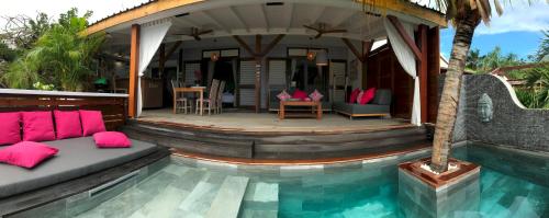a villa with a swimming pool and a house at Happy Cottage With Private Pool in Oyster Pond