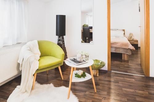 een woonkamer met een groene stoel en een tafel bij Apartments Dijana in Zagreb