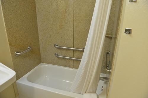 a bathroom with a tub and a shower curtain at Candlewood Suites Melbourne-Viera, an IHG Hotel in Viera