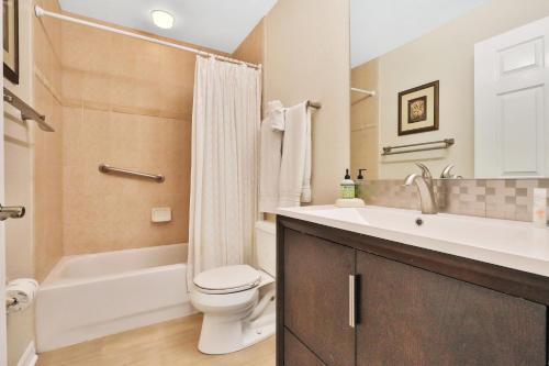 a bathroom with a toilet and a sink and a bath tub at Oceanside 404 in Clearwater Beach