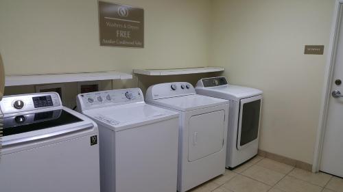 a kitchen with white appliances and a sign on the wall at Candlewood Suites Oklahoma City-Moore by IHG in Moore