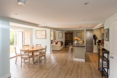 a kitchen and living room with a table and chairs at The Pink House, Thorpeness in Thorpeness