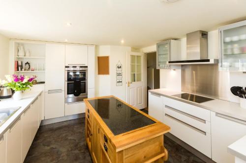 a kitchen with white cabinets and a black counter top at The Tower in Thorpeness