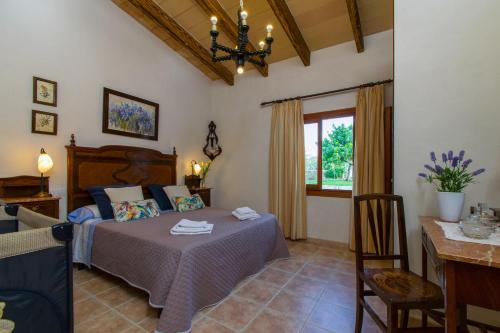 a bedroom with a bed and a table and a dining room at Finca SA ROTA in Ariany