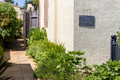 a sign on the side of a building with plants at The Tower in Thorpeness