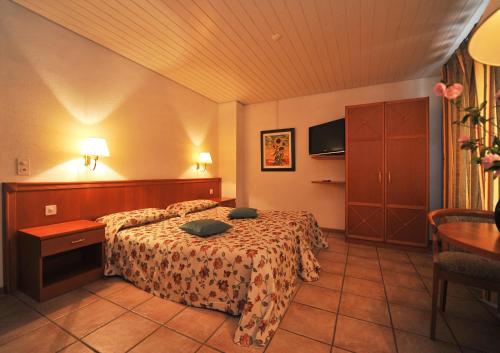 a hotel room with two beds and a table at Hotel Ristorante Grotto Serta in Lamone