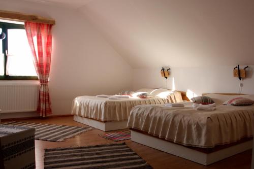 um quarto com 2 camas e uma janela em Hanul Kassay em Frumoasa
