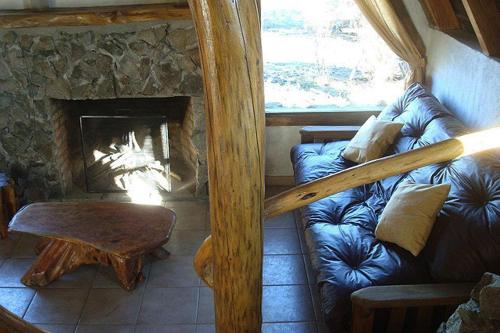 a living room with a couch and a fireplace at Del Viejo Camino in El Bolsón