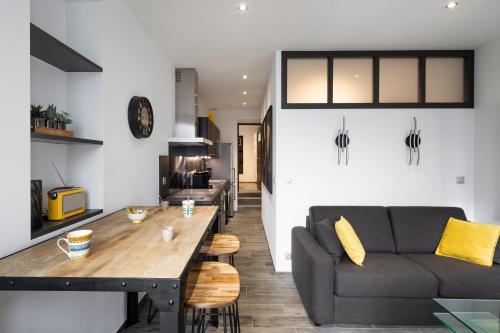 un salon avec un canapé et une table dans l'établissement Le Deriveur by Cocoonr, à Saint-Malo