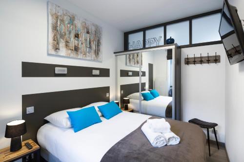 a bedroom with two beds with blue and white pillows at Le Deriveur by Cocoonr in Saint Malo