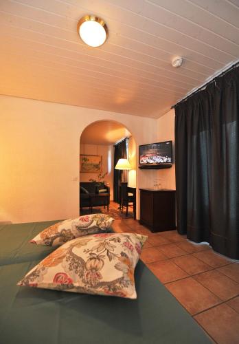 a bedroom with two beds and a flat screen tv at Hotel Ristorante Grotto Serta in Lamone