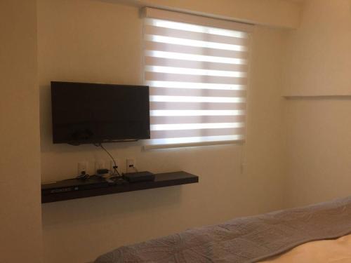 a bedroom with a flat screen tv and a window at Suite Única privada Loft céntrico Zaragoza y Tecnológico 178B in Casa Blanca La Corregidora