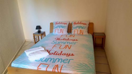 - une chambre dotée d'un lit avec les mots d'été dans l'établissement Appartement Les Marines de Moriani, à San-Nicolao