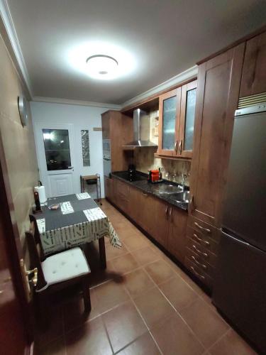 a kitchen with wooden cabinets and a table in it at Vivienda vacacional in Puerto del Rosario