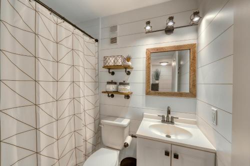 ein Badezimmer mit einem Waschbecken, einem WC und einem Spiegel in der Unterkunft Pink Pineapple in Hilton Head Island