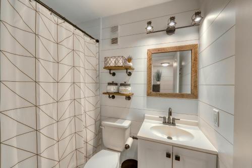 a bathroom with a sink and a toilet and a mirror at Pink Pineapple in Hilton Head Island