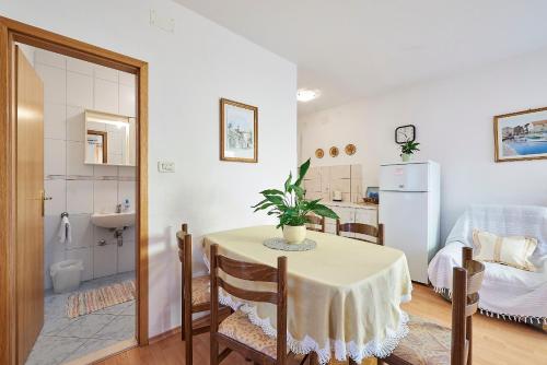 Il comprend une cuisine et une salle à manger avec une table et un réfrigérateur. dans l'établissement Apartment Ivanka - 200 m from sea, à Trogir