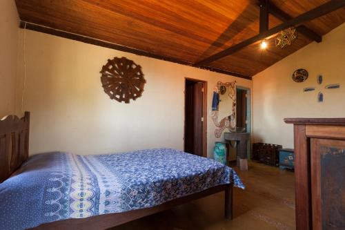 1 dormitorio con cama y techo de madera en Casa Aconchego do Sol 5 minutos do centro, en São Gonçalo do Rio das Pedras