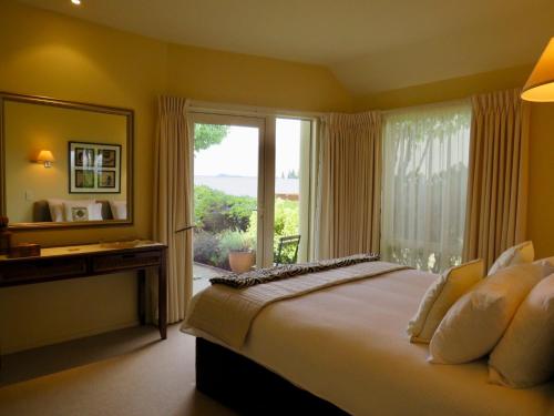 a bedroom with a large bed and a large window at Ultimate View - Lake Tekapo in Lake Tekapo