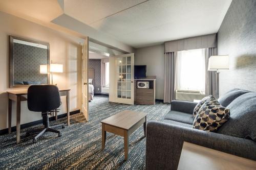 a hotel room with a couch and a table at Monte Carlo Inn Brampton in Brampton