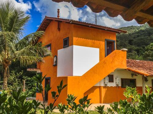 an orange house with a white sign in front of it at Lagamar Ecohotel in Cananéia