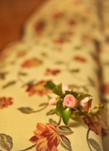 a pink rose sitting on top of a bed at Hotel Ristorante Grotto Serta in Lamone