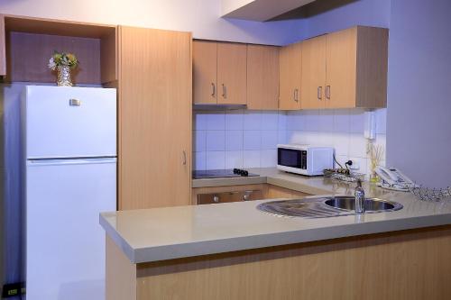 a kitchen with a white refrigerator and a sink at Flinders Landing Apartments in Melbourne