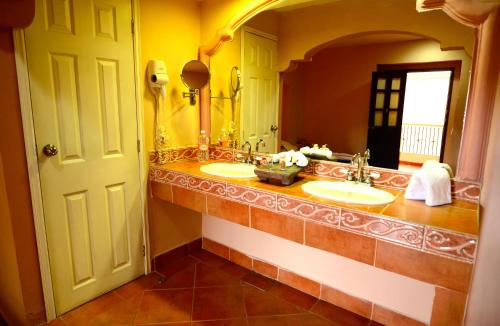 a bathroom with two sinks and a large mirror at Hotel Real Catedral in Tula de Allende